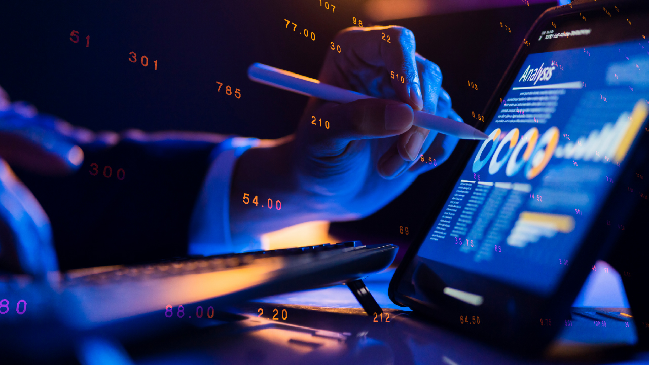 A businesswoman studying statistics and graphs on a tablet computer.