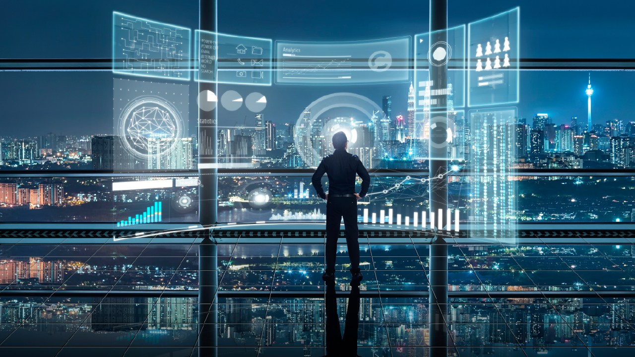 A businessman studying a digital dashboard over a modern cityscape.