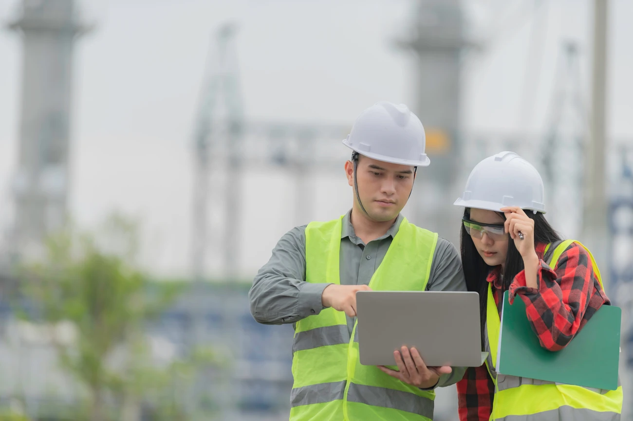 Two engineers, one male and one female, analysing data.